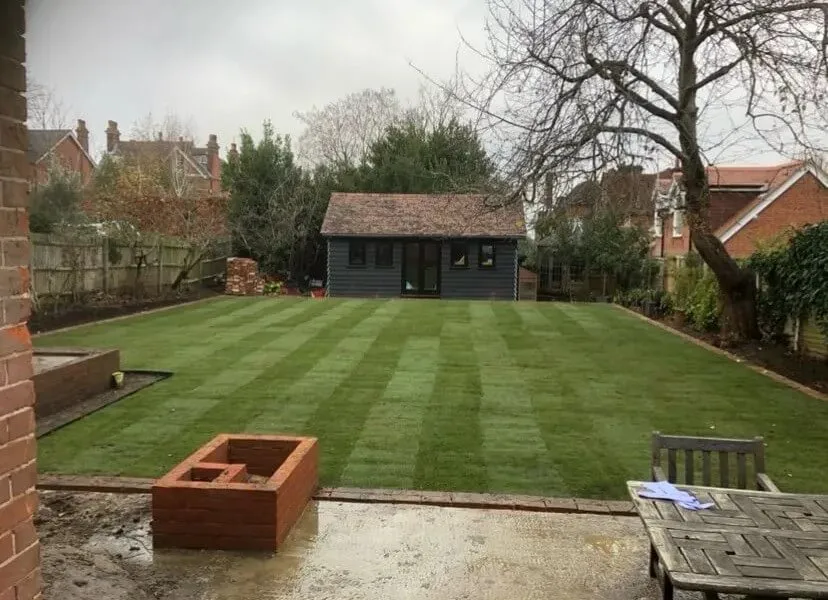 a backyard with a lawn and a wooden table